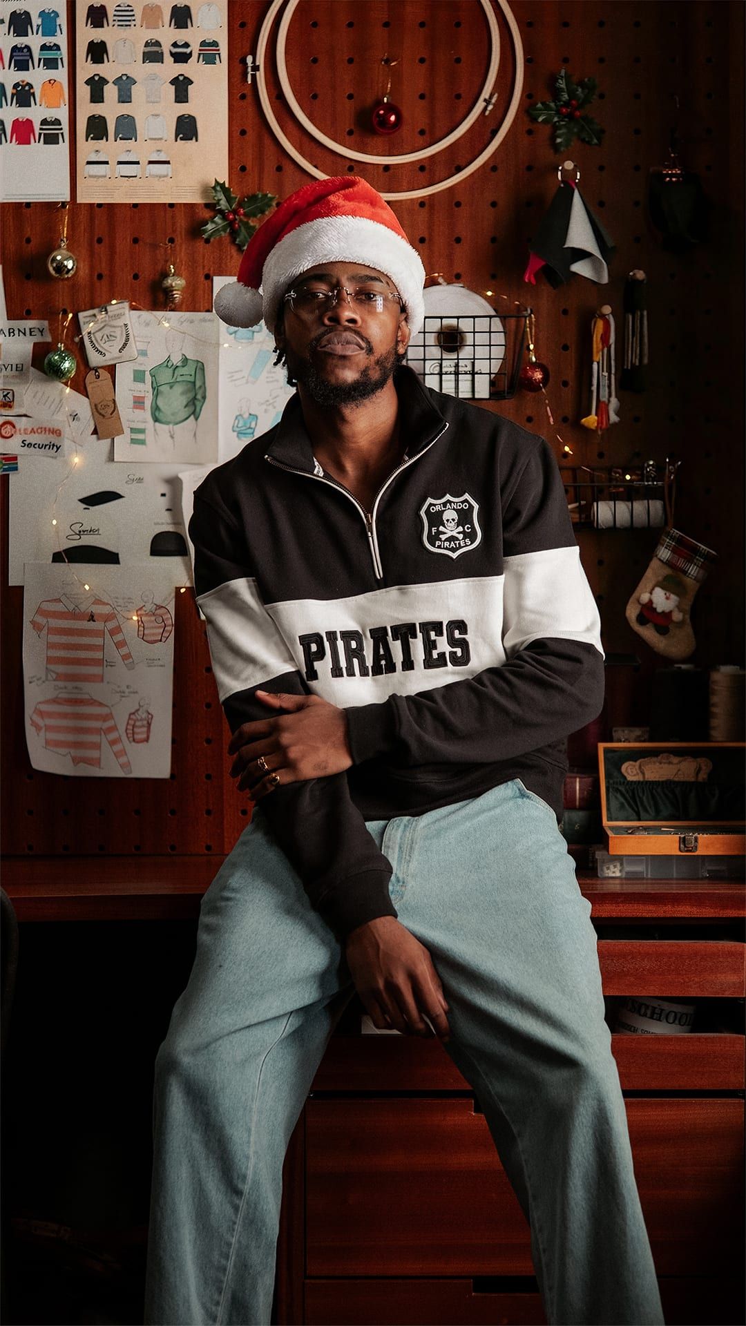 Pirates quarter-zip and Santa hat at a design studio bench