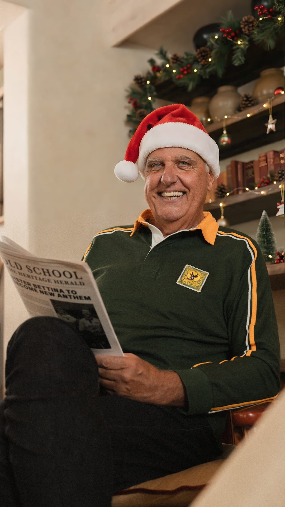 Older man in Springbok polo and Santa hat reading the Old School Heritage Herald